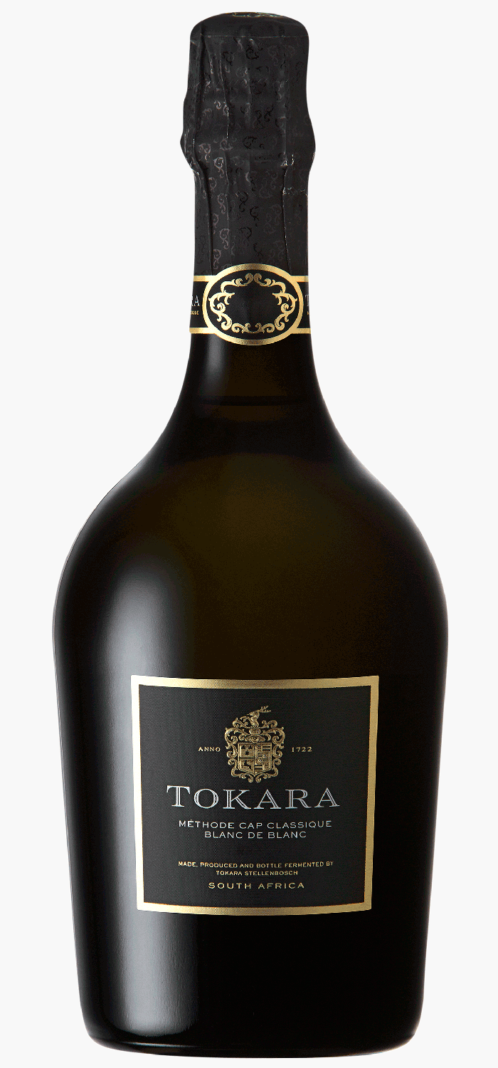 Eine Flasche Tokara Méthode Cap Classique Blanc de Blancs Schaumwein aus Südafrika steht neben der eleganten grau-gold marmorierten Geschenkbox.