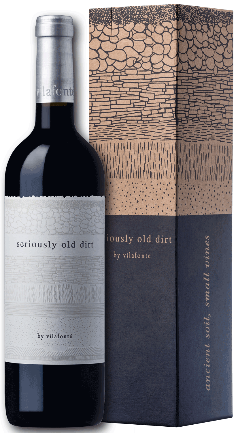Eine Rotweinflasche mit der Aufschrift "seriously old dirt by vilafonté" steht neben der dazugehörigen Schachtel, die mit strukturierten Mustern und erdfarbenen Motiven verziert ist. Auf der Schachtel steht "ancient soil", auf der Seite "small vines".