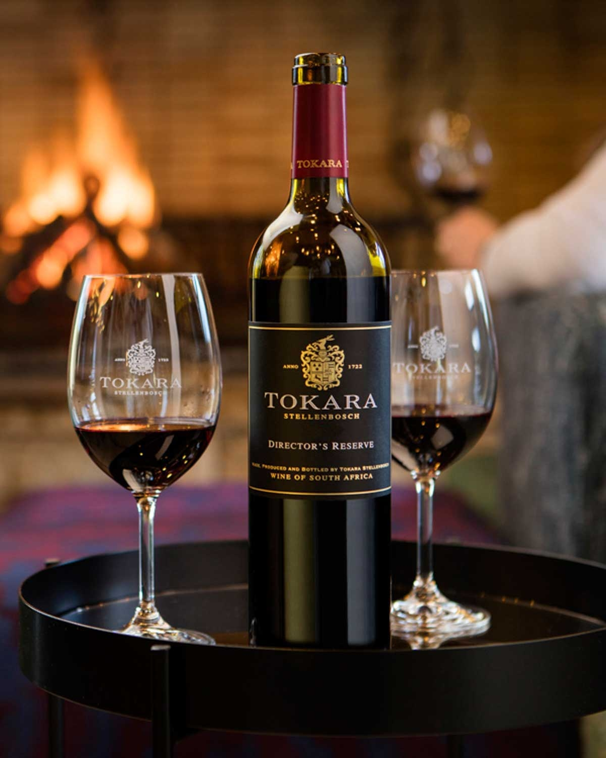 Eine Flasche Tokara Director's Reserve Rotwein aus Stellenbosch, Südafrika. Die Flasche hat ein schwarzes, goldfarbenes Etikett mit einem Wappen und goldenem Text und eine dunkelrote Kapsel, die den Deckel bedeckt.