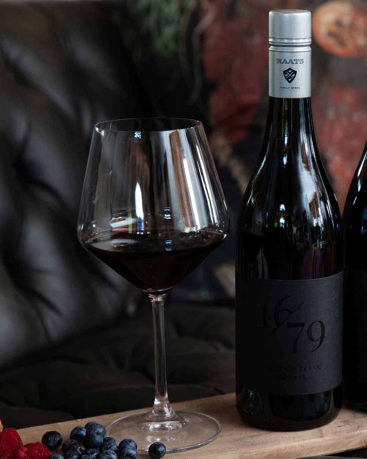 Eine dunkle Weinflasche mit silbernem Verschluss und der Aufschrift RAATS FAMILY WINES, mit 1679 und CABERNET FRANC RESERVE in schwarzer Schrift auf einem schwarzen Etikett.