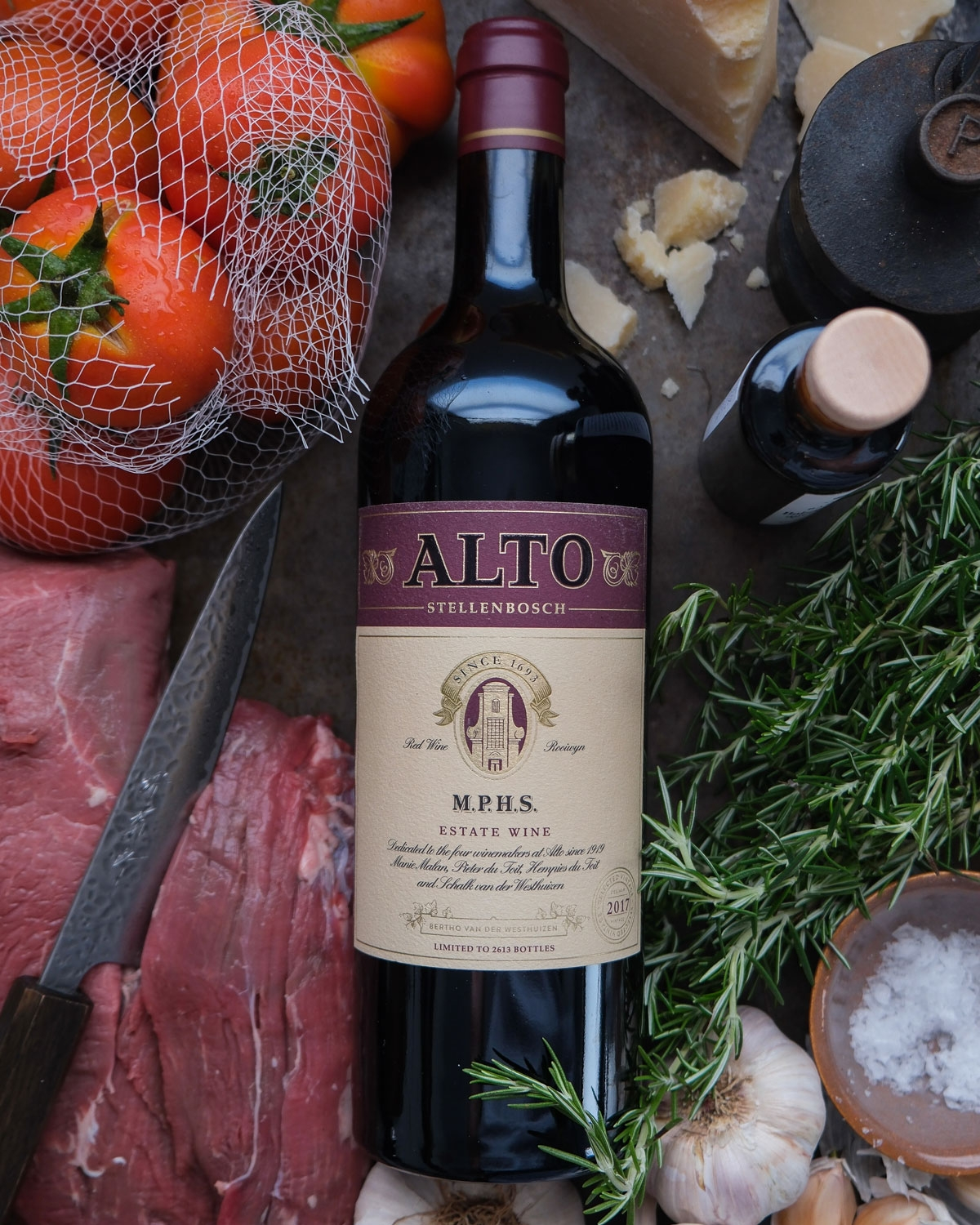 Eine Flasche Alto Stellenbosch-Rotwein mit kastanienbraunem und goldenem Etikett, auf dem das Alto-Logo, Angaben zum Weingut und eine kastanienbraune Folie auf dem Deckel abgebildet sind.