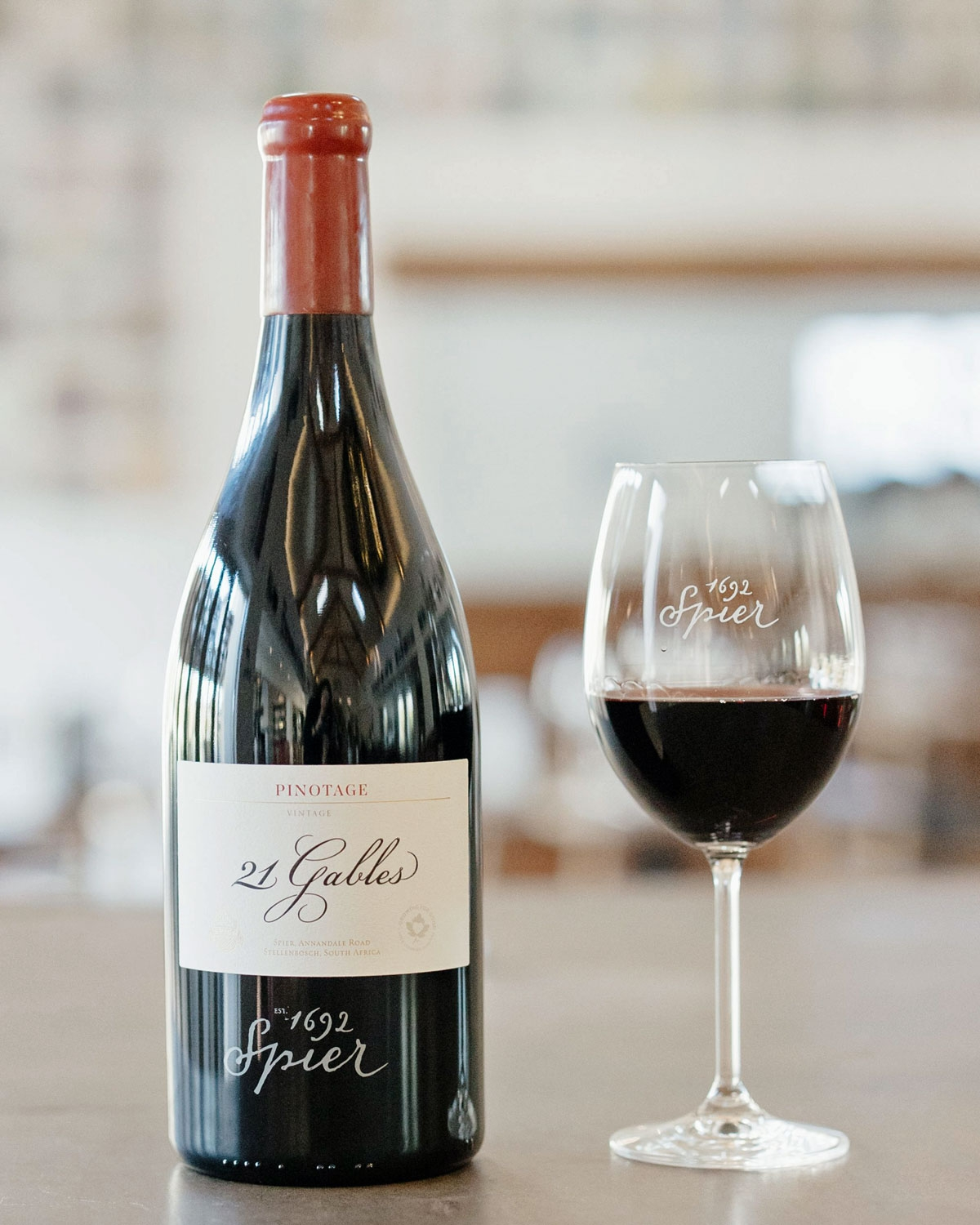 Eine Flasche Spier 21 Gables Pinotage-Wein mit rotem Folienverschluss und weißem Etikett mit schwarzem und rotem Text, darunter der Name des 1692 gegründeten Weinguts Spier.
