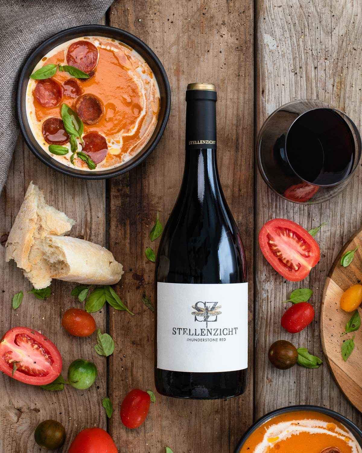 Eine dunkle Glasflasche Stellenzicht Thunderstone Rotwein mit einem schwarzen, goldfarbenen Verschluss und einem cremefarbenen Etikett mit dem Stellenzicht-Logo und -Text.
