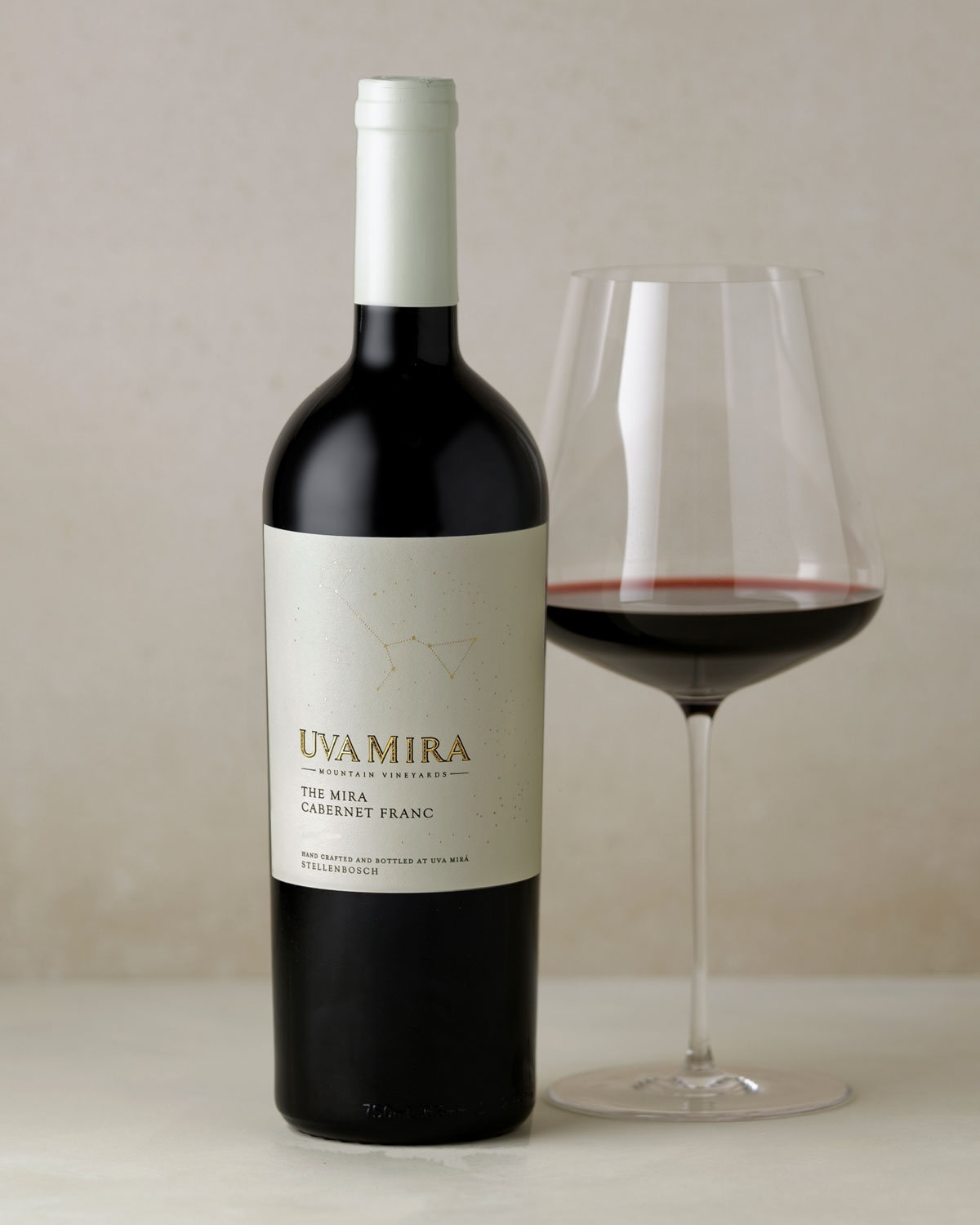 Eine Flasche des Weins Uva Mira Mountain Vineyards mit der Bezeichnung The Mira Cabernet Franc. Das cremefarbene Etikett zeigt eine Sternbildgrafik und einen in Gold geprägten Text. Die Flasche hat ein dunkles Glas mit einer schwarzen Folienkapsel.