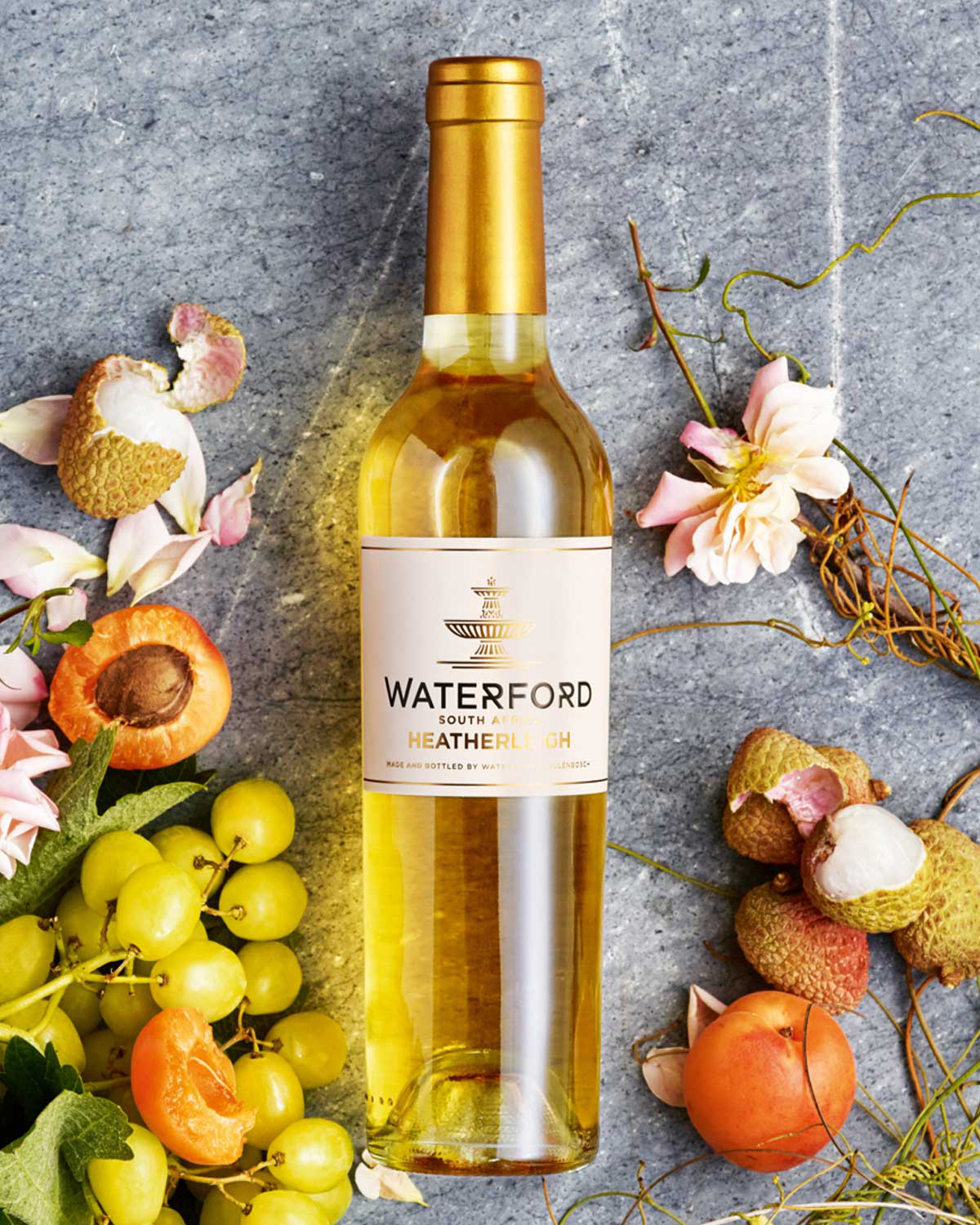 Eine Flasche Waterford Heatherleigh Wein aus Südafrika mit einem goldenen Verschluss und einem weißen Etikett mit goldener und schwarzer Schrift und einem dekorativen Emblem.
