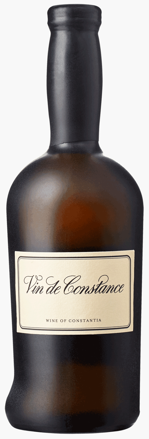 Eine Flasche Vin de Constance, ein natürlicher Süßwein aus Klein Constantia, Südafrika, wird neben ihrer dunklen, eleganten Schachtel mit passendem Branding und goldener Beschriftung gezeigt.