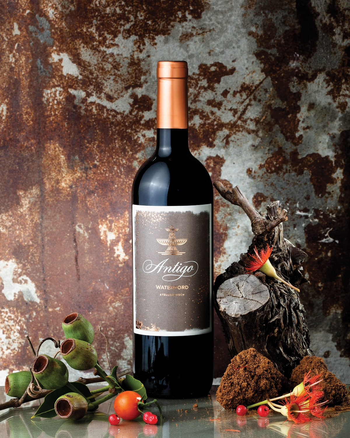 Eine dunkle Weinflasche mit einem kupferfarbenen Folienverschluss und einem rustikalen braunen Etikett, auf dem in eleganter Schrift das Wort "Antigo" sowie "WATERSHED" und weiterer kleinerer Text zu lesen ist.