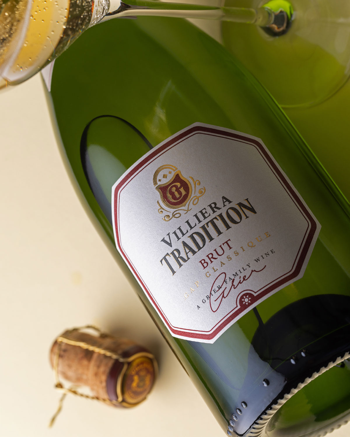 Eine Flasche Villiera Tradition Brut Schaumwein mit Goldfolie, weißem und rotem Etikett und der Aufschrift Methode Cap Classique und Cape Sparkling Wine auf der Vorderseite.