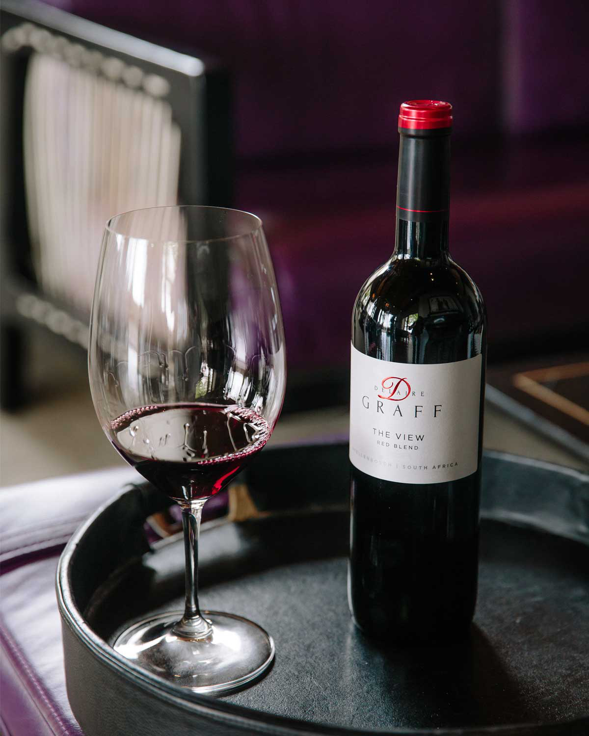 Eine Flasche De Drek Graff The View Red Blend Wein mit weißem Etikett und roten Akzenten, aufrecht stehend vor einem hellen Hintergrund.