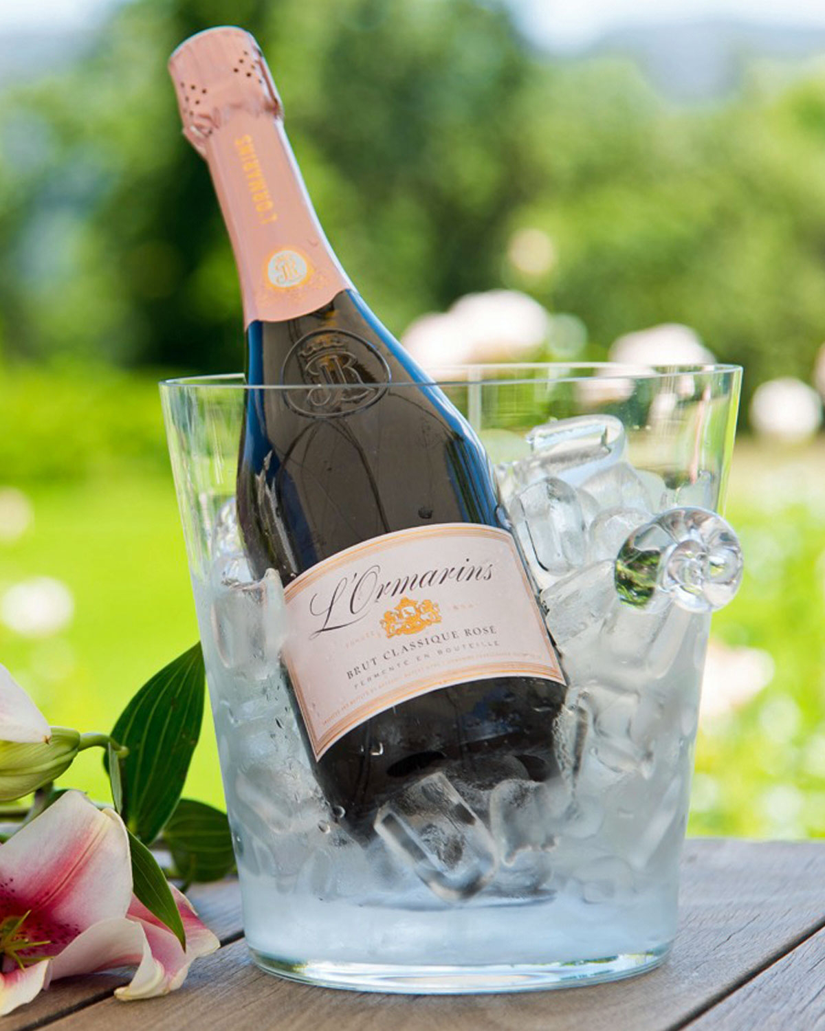 Eine Flasche L'Ormarins Brut Classique Rosé Sekt mit einem rosa Folienverschluss, geprägtem Logo und einem rosa-goldenen Etikett auf der Vorderseite.