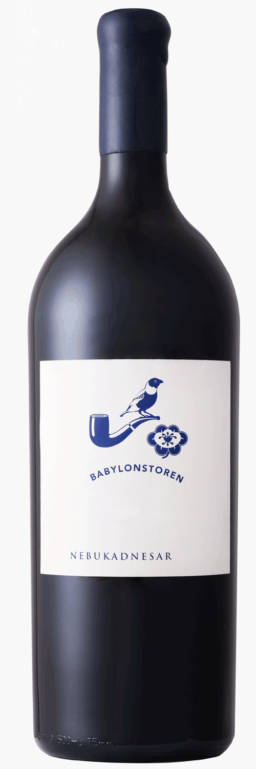 Eine große dunkle Weinflasche mit der Aufschrift Babylonstoren Nebukadnesar steht vor einer Holzkiste mit eingravierten Blumen- und Hornmotiven.