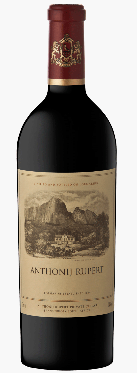 Eine Flasche Anthonij Rupert Rotwein steht vor einem dunkelblauen Präsentationskarton mit goldenen Verzierungen und Text. Das Weinetikett zeigt eine Illustration von Bergen und Weinbergen.