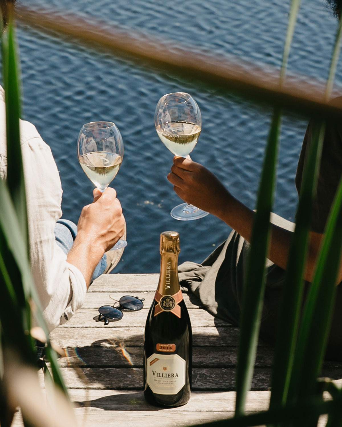 Eine Flasche Villiera Brut Natural Chardonnay Sekt mit einem Hals aus Goldfolie, roten und goldenen Akzenten und einem weißen Etikett mit dem Markennamen und Produktangaben.