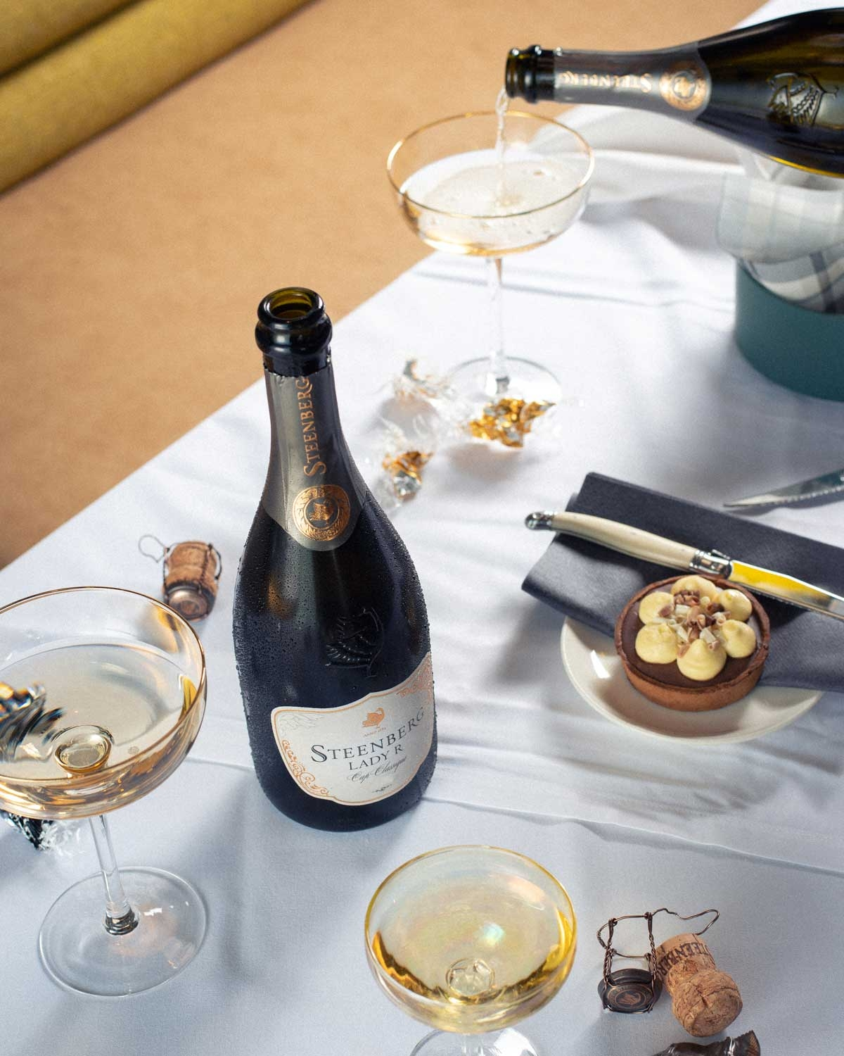 Eine Flasche Steenberg Lady R Cap Classique Sekt mit Goldfolie am Hals und einem eleganten weiß-goldenen Etikett mit dem Steenberg-Logo.