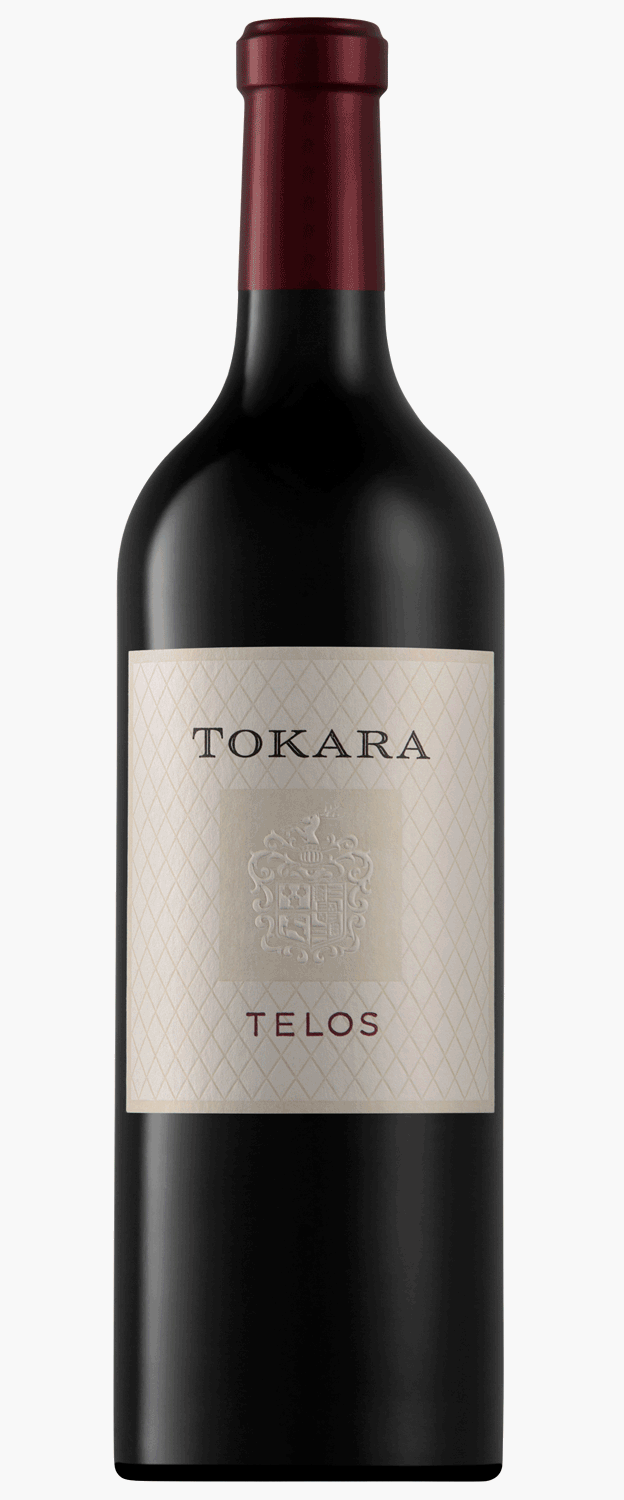 Eine Flasche Tokara Telos Rotwein mit rotem Foliendach steht neben einer eleganten schwarzen und holzgemusterten Geschenkbox.