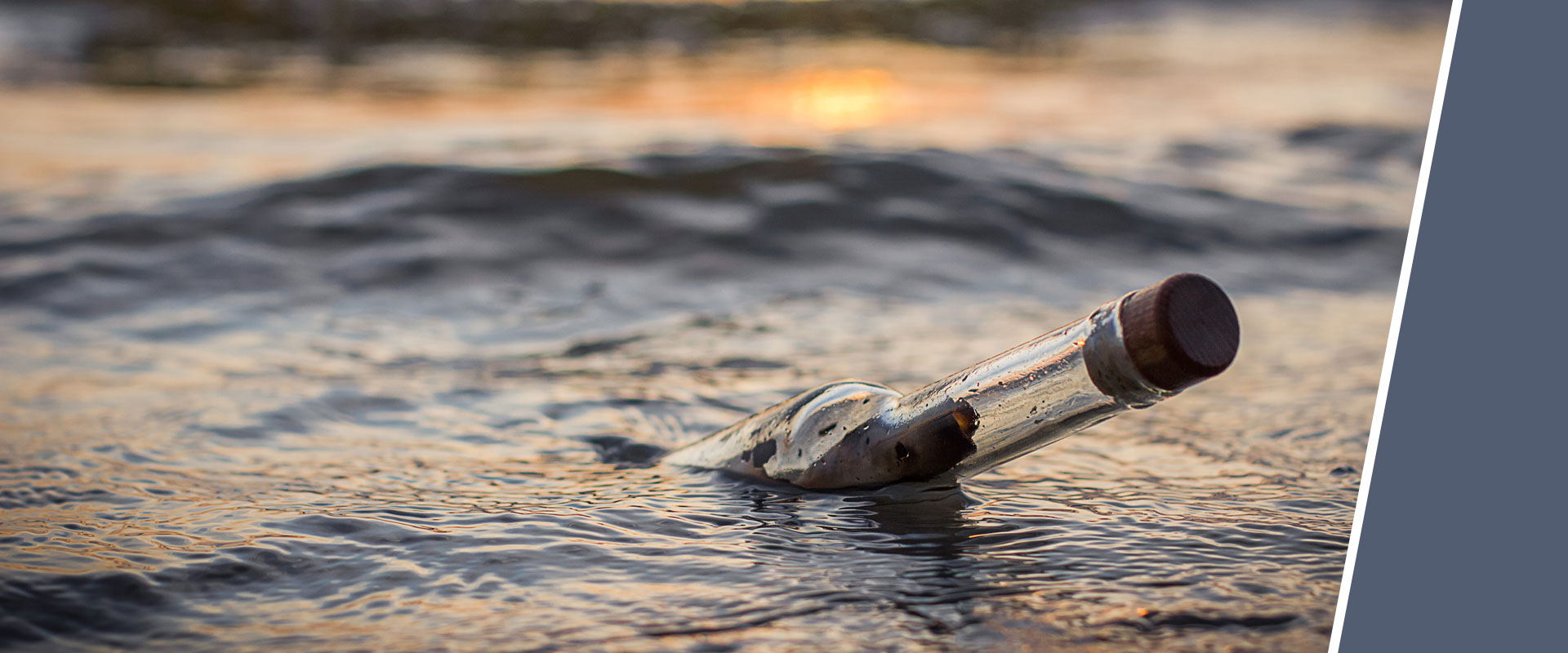 Flasche mit Korken treibt auf dem Wasser bei Sonnenuntergang