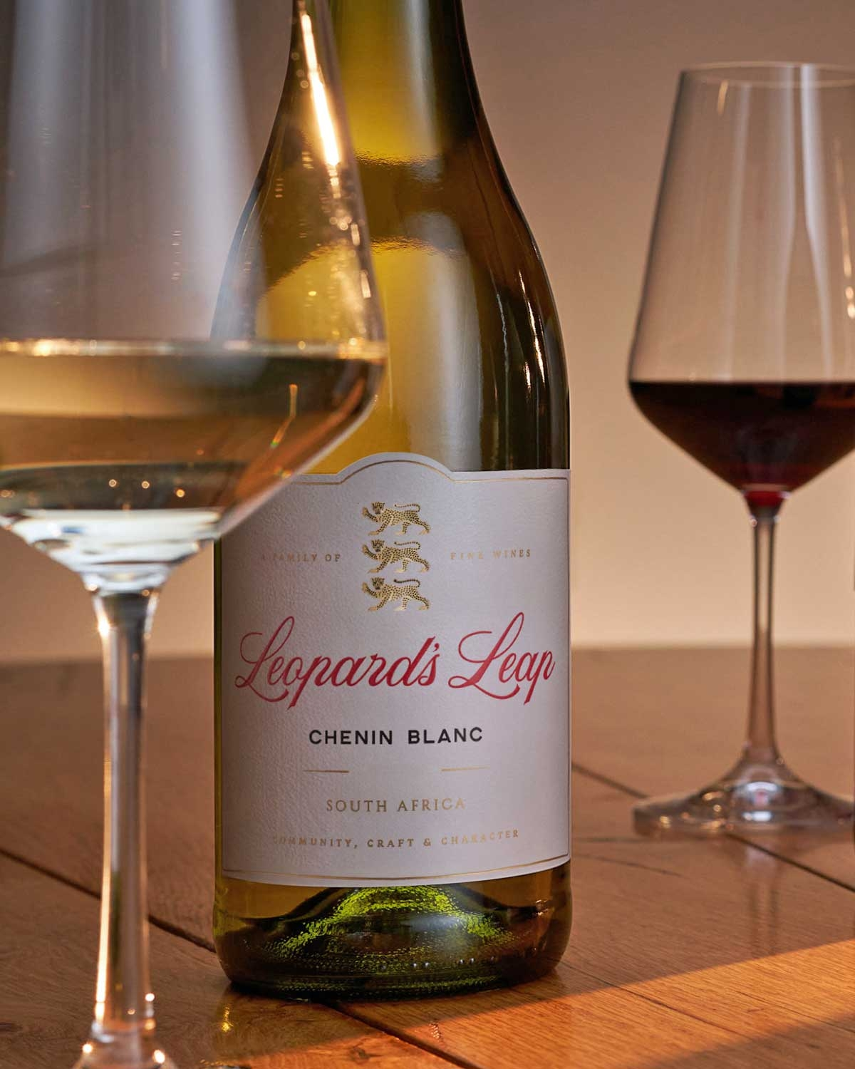 Eine Flasche Leopards Leap Chenin Blanc mit rotem Verschluss, goldener und roter Schrift auf weißem Etikett und einem goldenen Leoparden-Emblem. Der Wein ist aus Südafrika.