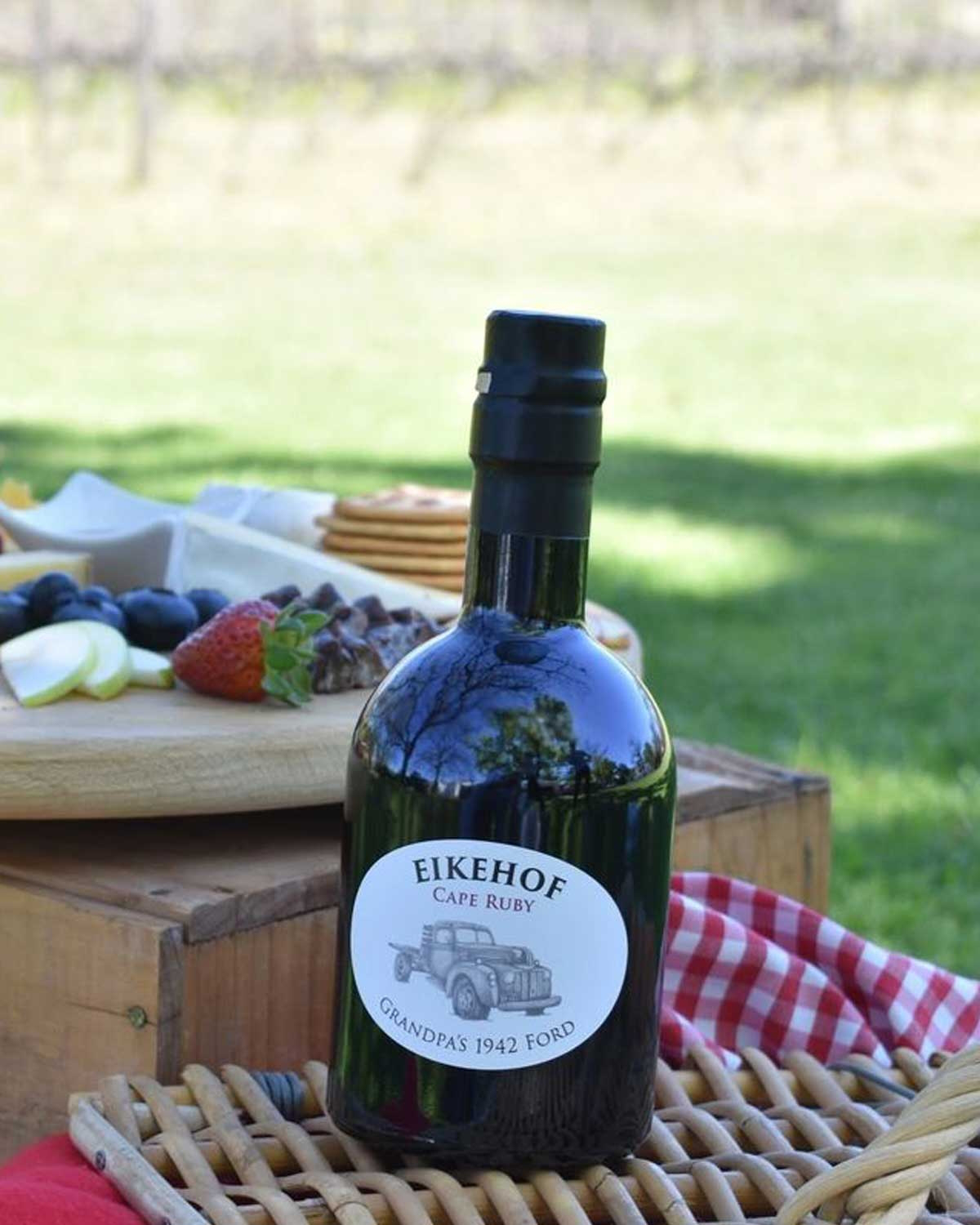 Eine dunkle Weinflasche mit der Aufschrift EIKEHOF Cape Ruby, die eine Illustration eines alten Pickups und den Text GRANDPAS 1942 FORD auf einem weißen ovalen Etikett zeigt.