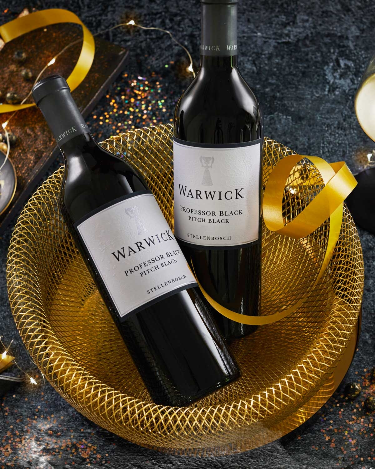 Eine Flasche Warwick Professor Black Pitch Black Rotwein aus Stellenbosch, mit einem silber-schwarzen Etikett und einer schwarzen Folienkapsel am Hals.