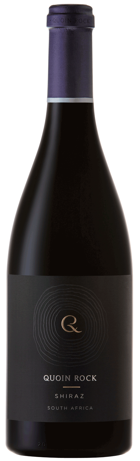 Eine dunkle Glasflasche mit dem Wein Quoin Rock Shiraz aus Südafrika, mit einem schwarzen Etikett mit goldener und weißer Schrift und einer violetten Folie auf dem Deckel.