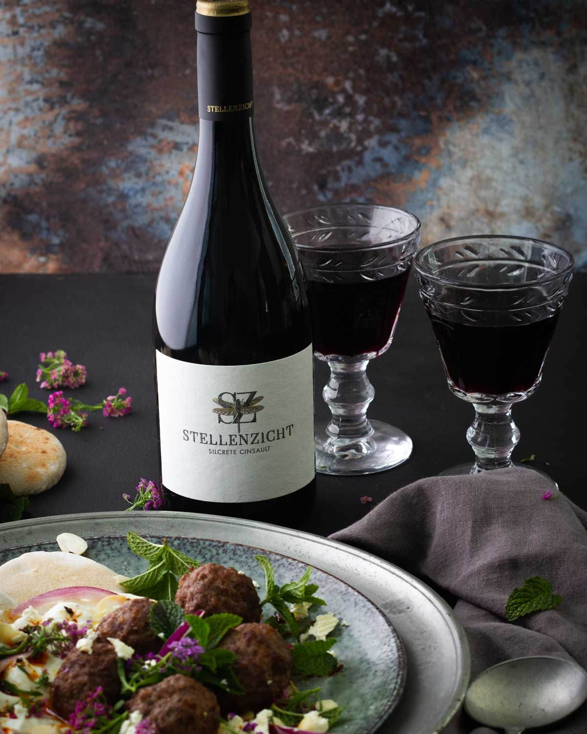 Eine dunkle Weinflasche mit einem gold-schwarzen Verschluss und einem Etikett mit der Aufschrift Stellenzicht Silcrete Cinsault und einem dekorativen Emblem über dem Text.