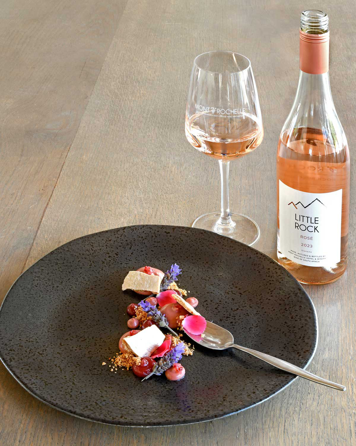 Eine Flasche Little Rock Rosé-Wein in hellem Rosa mit Schraubverschluss und cremefarbenem Etikett, auf dem der Markenname, eine Berggrafik und Angaben zum Wein stehen.